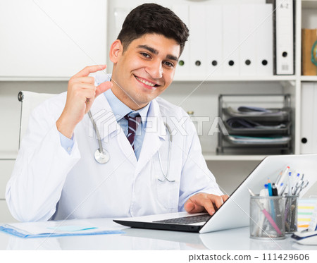 Young smiling male is doing report about patients Young smiling male is doing report about patients 111429606