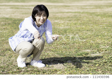 戶外育兒期間，女保育員在公園草地上玩耍 111430396