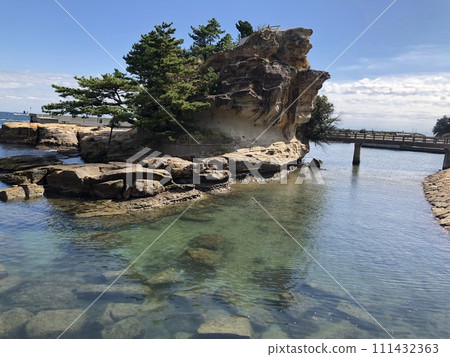 Blue sea, blue sky, and rugged rocks visible from the coast 111432363