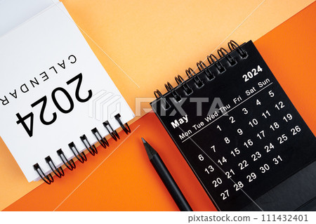 May 2024 desk calendar black and white color with pencil on orange background. 111432401