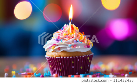 colorful cupcake with candle and sprinkles on blur festive background colorful cupcake with candle and sprinkles on blur festive background 111432453