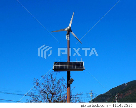 一種利用小型風力發電機和太陽能板的混合式路燈，安裝在藍天之下。 111432555