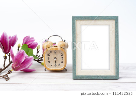 Blank picture frame and alarm clock on wooden floor with copy space. 111432585