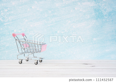 Empty toy metal supermarket shopping cart on wooden floor. 111432587