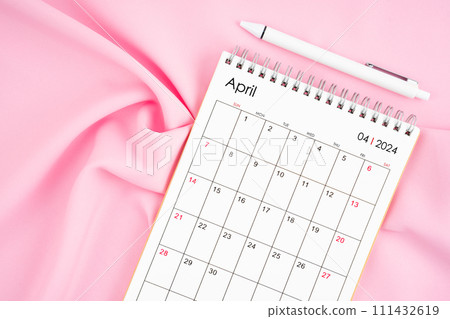 April 2024 month calendar and pen on pink fabric background. 111432619