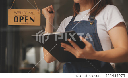 Startup successful small business owner sme beauty girl stand with tablet smartphone in coffee shop restaurant. Portrait of asian tan woman barista cafe owner. SME entrepreneur seller business concept Startup successful small business owner sme beauty girl stand with tablet smartphone in coffee shop restaurant. Portrait of asian tan woman barista cafe owner. SME entrepreneur seller business concept 111433075