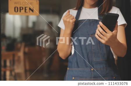 Startup successful small business owner sme beauty girl stand with tablet smartphone in coffee shop restaurant. Portrait of asian tan woman barista cafe owner. SME entrepreneur seller business concept 111433076