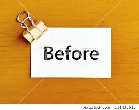 Memo paper with Before text sandwiched between double clips 111433615