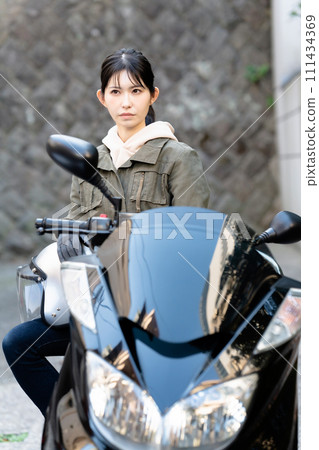A woman riding a motorcycle 111434369