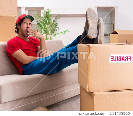 Young male contractor with boxes working indoors Young male contractor with boxes working indoors 111435990