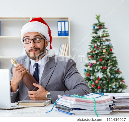 Young businessman celebrating christmas in the office 111436027