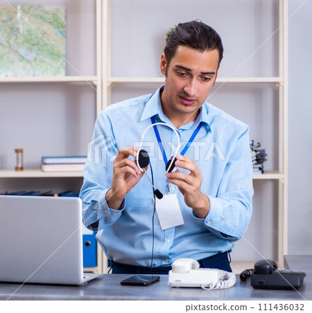 Young male travel agent working in the office Young male travel agent working in the office 111436032