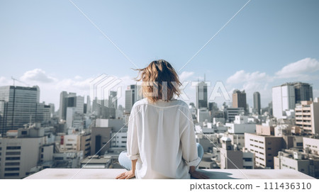 Rear view of a woman looking at the city from the rooftop 111436310