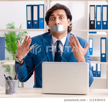Young male employee with tape on the mouth Young male employee with tape on the mouth 111436433