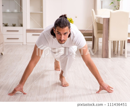 Young man doing physical exercises at home 111436451