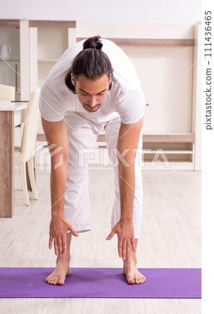 Young man doing physical exercises at home 111436465
