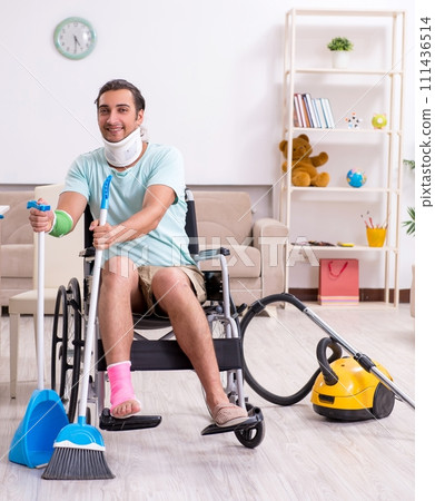 Young man in wheel-chair cleaning the house Young man in wheel-chair cleaning the house 111436514
