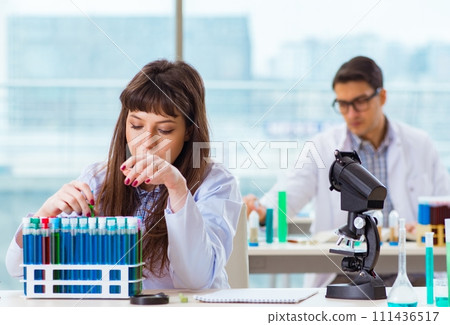 Two chemists working in lab experimenting 111436517