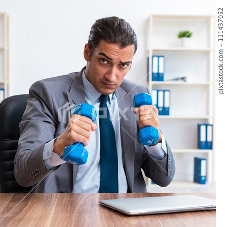 Young handsome employee doing sport exercises at workplace 111437052