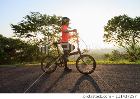 Riding folding bike on sunny mountain top road Riding folding bike on sunny mountain top road 111437257