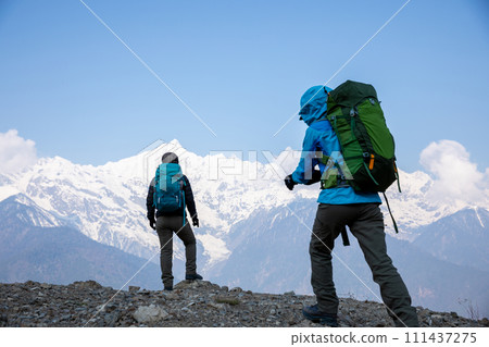 Two women backpackers hiking  in beautiful winter high altitude mountains 111437275