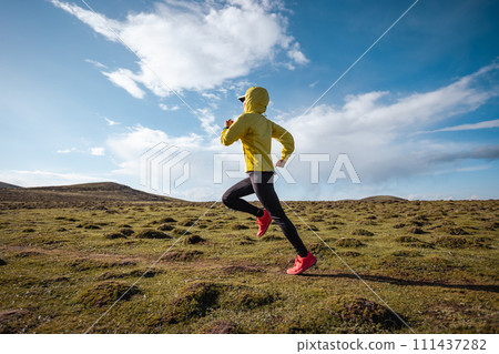 Woman trail runner cross country running to high altitude mountain peak Woman trail runner cross country running to high altitude mountain peak 111437282