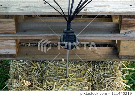 Integrated Solar Cell LED with pole on the straw seat on the front wooden pallet. Integrated Solar Cell LED with pole on the straw seat on the front wooden pallet. 111440219