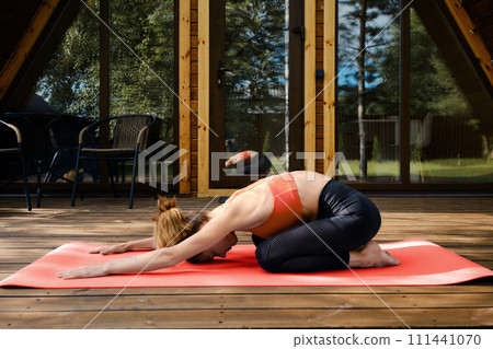 Woman does stretching exercises outdoors Woman does stretching exercises outdoors 111441070