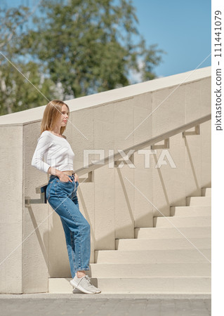 Woman standing on stairs in profile 111441079
