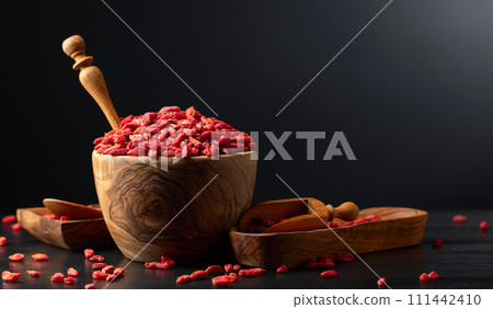 Dried goji berries on a black background. Dried goji berries on a black background. 111442410