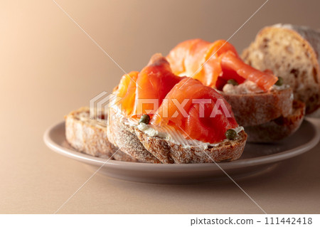 Sandwich with smoked trout, cream cheese, and capers. 111442418