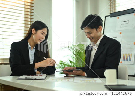 Young businesspeople analyzing graphs and charts, preparing economic report at office Young businesspeople analyzing graphs and charts, preparing economic report at office 111442676