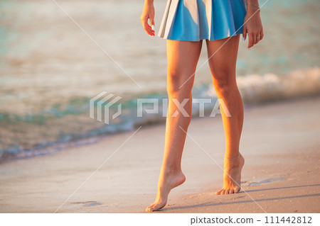 Teen girl's legs on the beach closeup. Girl walking on the beach Teen girl's legs on the beach closeup. Girl walking on the beach 111442812