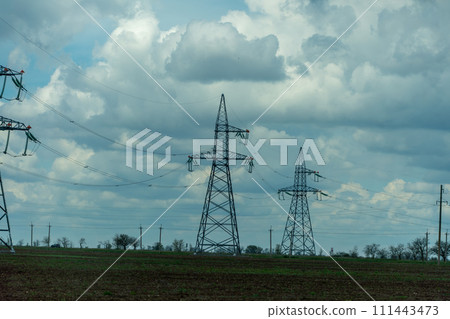 High voltage towers with sky background. Power line support with wires for electricity transmission. High voltage grid tower with wire cable at distribution station. Energy industry, energy saving High voltage towers with sky background. Power line support with wires for electricity transmission. High voltage grid tower with wire cable at distribution station. Energy industry, energy saving 111443473