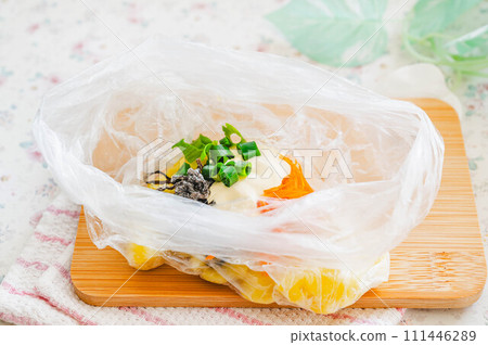 Put the potato salad ingredients into a plastic bag. 111446289