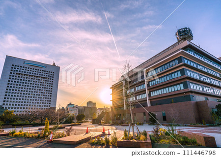 Yokohama cityscape in Japan - Yokohama Shinko Joint Government Building (right), Kanagawa Prefectural Police, and contrails reflected in the setting sun 111446798