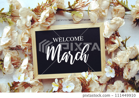 Welcome March text message with flower decoration on wooden background Welcome March text message with flower decoration on wooden background 111449910