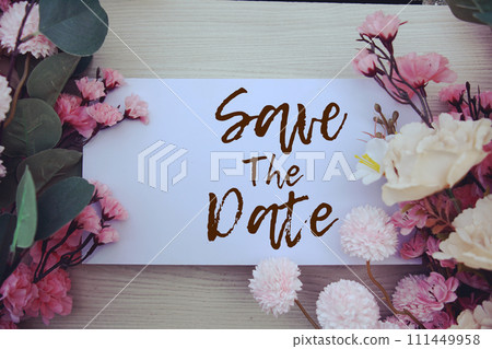 Save the Date text message with flower decoration on wooden background 111449958