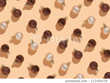 pattern of glittery Christmas balls in cream and chocolate colors on a beige background pattern of glittery Christmas balls in cream and chocolate colors on a beige background 111450270