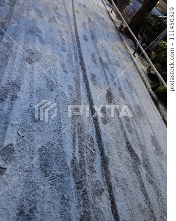 [Photo taken with a mobile phone] Footprints and wheel marks in the snow Location: Shinjuku-ku, Tokyo 111450329