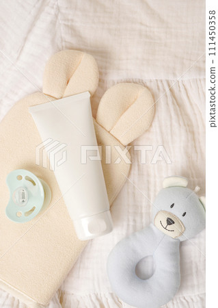white cream tube and baby accessories. light textile background, Care about clean and soft body skin. Daily children beauty product 111450358