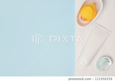 cosmetic cream for children with toy duck and pacifier on blue background cosmetic cream for children with toy duck and pacifier on blue background 111450359