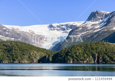 Svartisen Glacier in pristine white, framed by peaks, lake mirrors tranquility Svartisen Glacier in pristine white, framed by peaks, lake mirrors tranquility 111450494