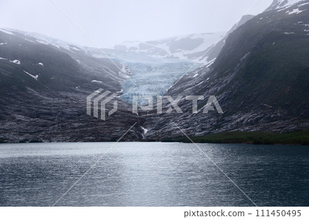 Glistening Svartisen Glacier flows into mirror-like lake, framed by Norway's mountains Glistening Svartisen Glacier flows into mirror-like lake, framed by Norway's mountains 111450495