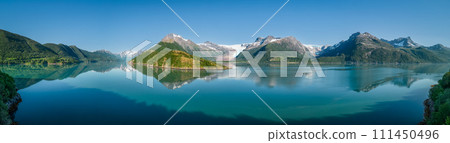 Idyllic super panorama of Svartisen Glacier by tranquil waters reflecting Saltfjell range  111450496