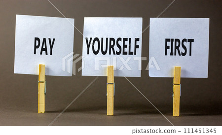Pay yourself first symbol. Concept words Pay yourself first on beautiful white paper on clothespin. Beautiful grey table grey background. Business and pay yourself first concept. Copy space. Pay yourself first symbol. Concept words Pay yourself first on beautiful white paper on clothespin. Beautiful grey table grey background. Business and pay yourself first concept. Copy space. 111451345