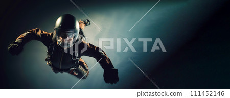 man in special uniform jumps with parachute, soars in air against background of sky, clouds. man in special uniform jumps with parachute, soars in air against background of sky, clouds. 111452146