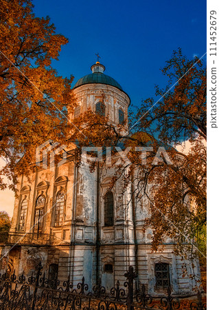 An old church with a green dome is surrounded by trees and bathed in sunlight. The Church of St. John the Evangelist is an Orthodox church and an architectural monument in Nizhyn. An old church with a green dome is surrounded by trees and bathed in sunlight. The Church of St. John the Evangelist is an Orthodox church and an architectural monument in Nizhyn. 111452679