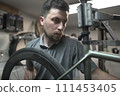 Repairing bicycle tire rim with automotive tire engineer using machine in garage 111453405