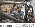 A man is working on a bicycle in a garage 111453417